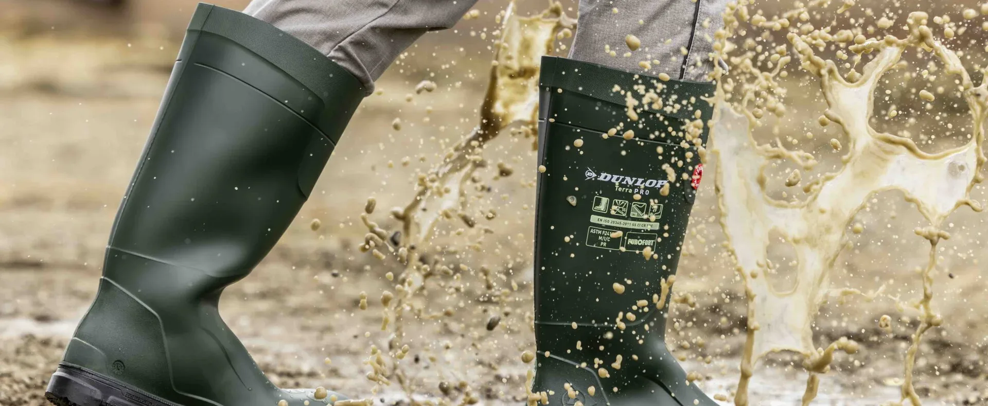 Dunlop boots walking through mud, with a splash